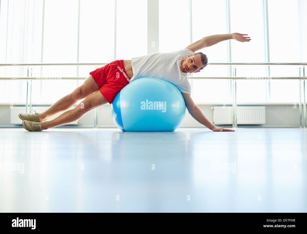 guy stretching on gym ball stock